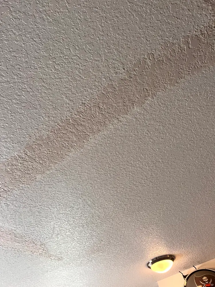 The repaired ceiling with the new texture blended into the original, no seam visible