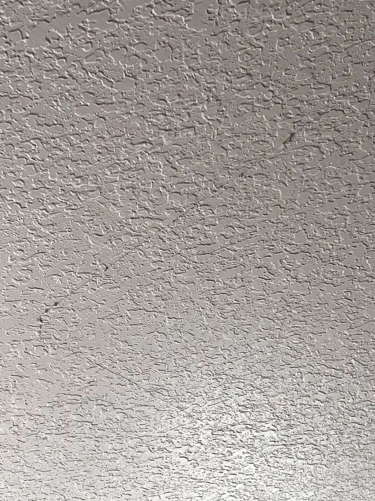 Hairline cracks running through the knockdown texture on a ceiling before repair