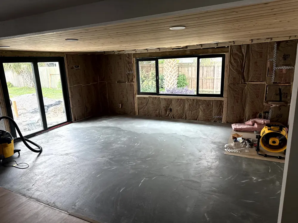 The same room addition framed and insulated under the wood ceiling before any drywall went up