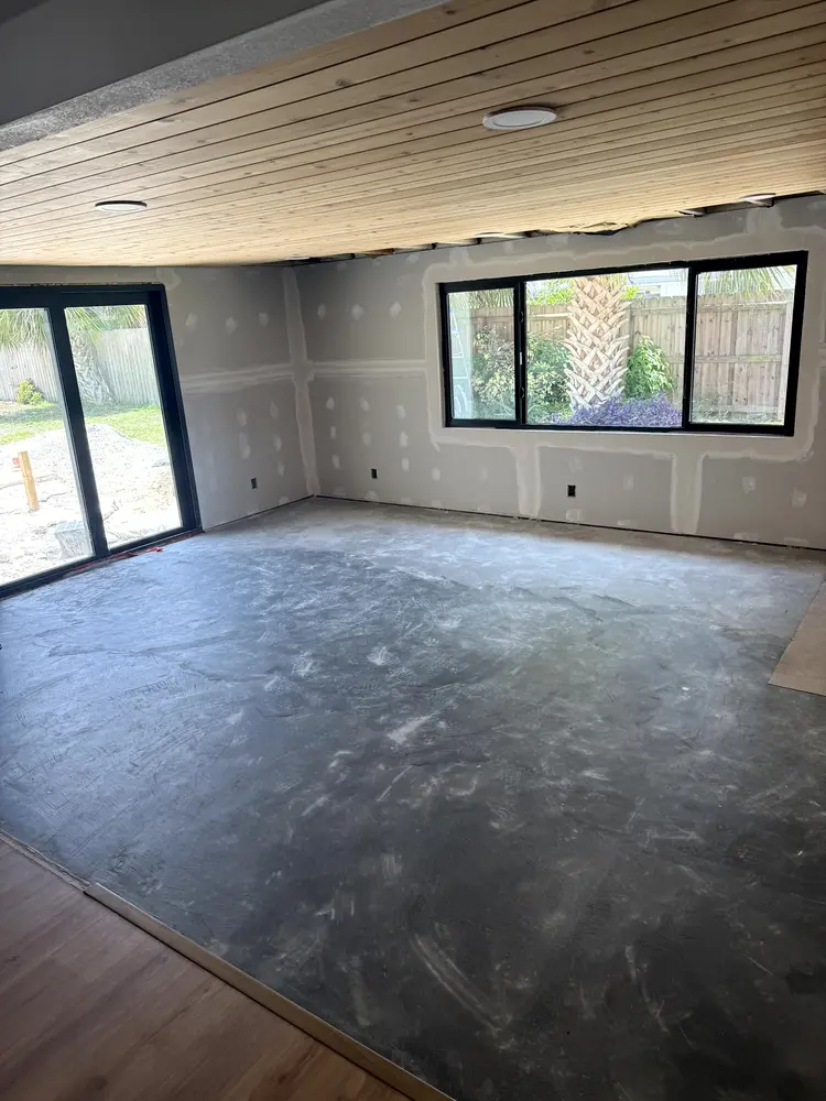Drywall hung in the room addition with the fasteners spotted and every seam taped