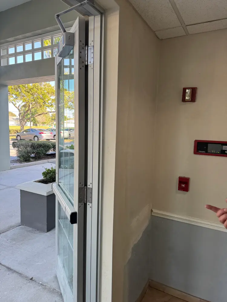 The rebuilt jamb wall finished flush and blended into the vestibule beside the storefront door